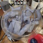 Work-in-progress hand-painted Skeletor statue parts on the painting bench before assembly.