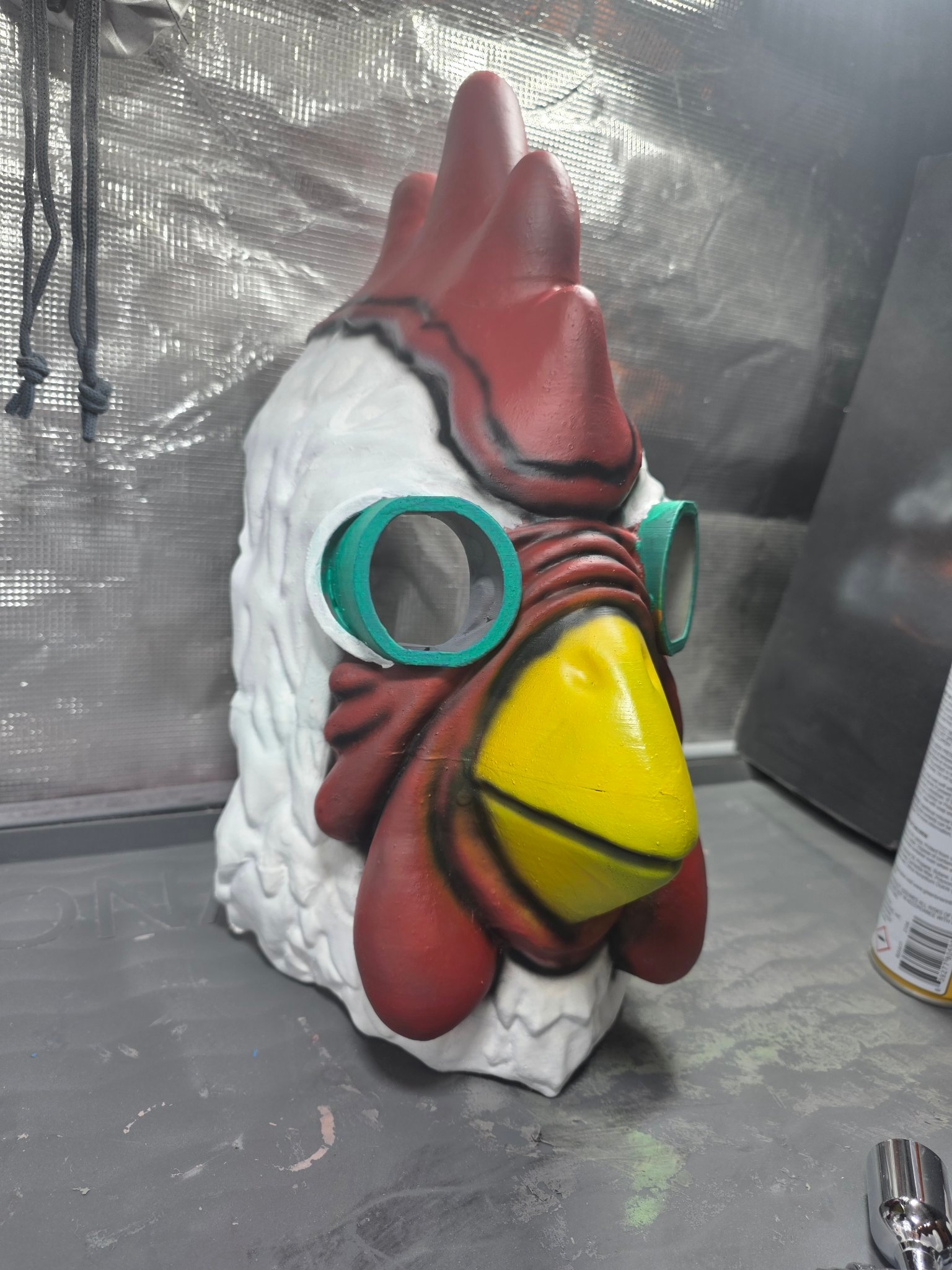 Three-quarter view of the finished hand-painted chicken mask